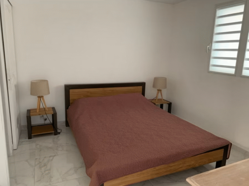 Chambre avec un lit queen size et deux tables de chevet.